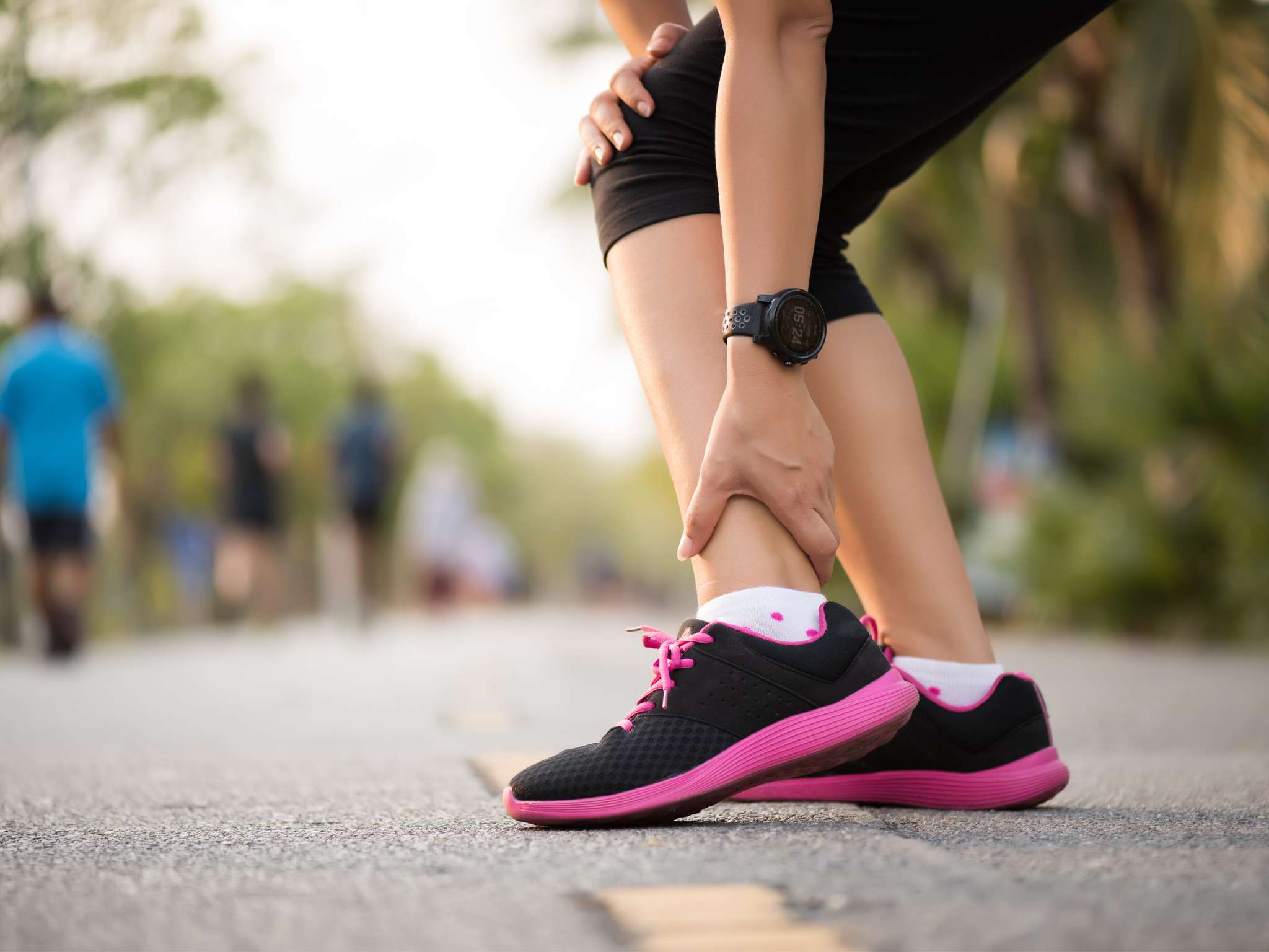 Woman suffering from an ankle injury while exercising. Running sport injury concept.